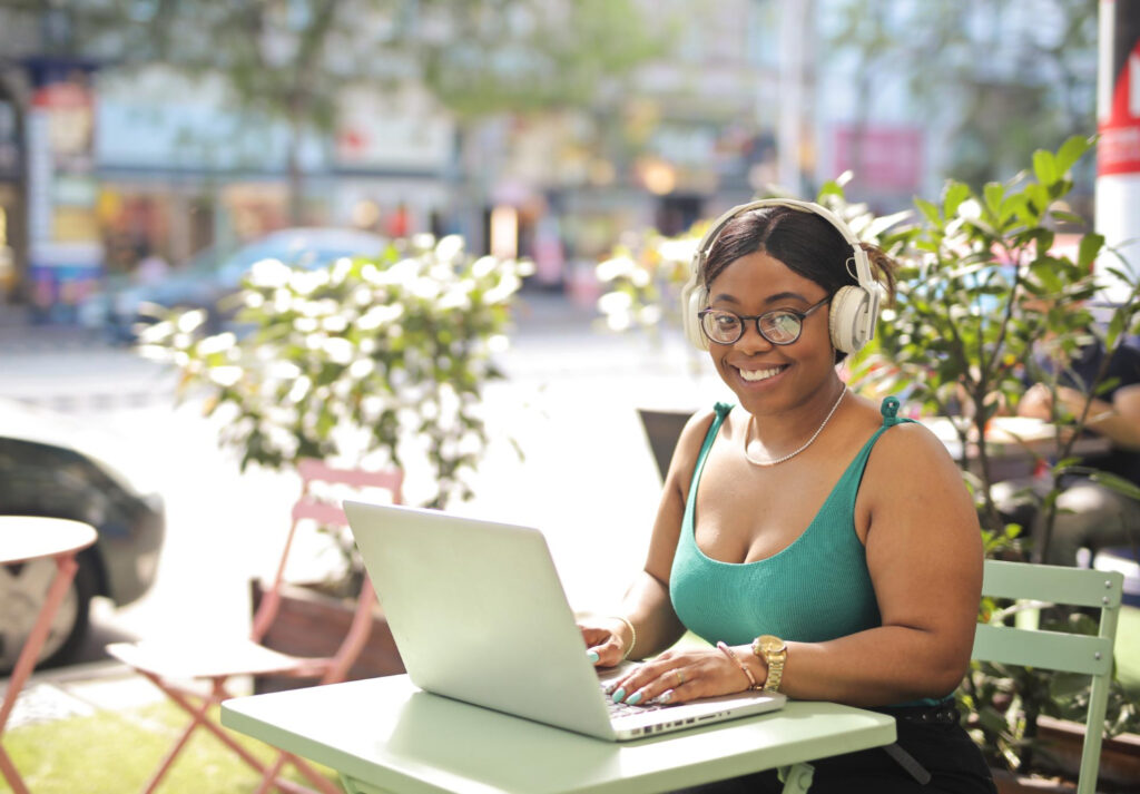 Domain - a woman using laptop while smiling -Gan Tech services